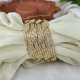 Gold bracelet with diamond accents on a white fabric background