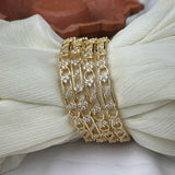 Gold bracelet with diamond accents on a white fabric background