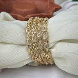 Gold bracelet with diamond accents on a white fabric background