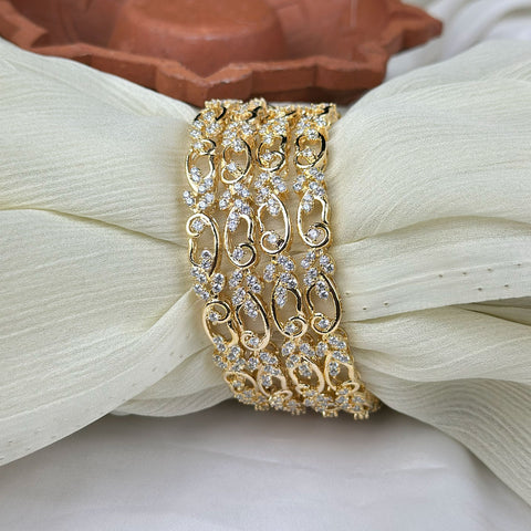 Gold bracelet with intricate design on a white fabric background