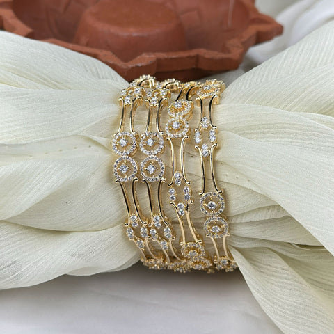 Gold bracelet with diamond accents on a white fabric background