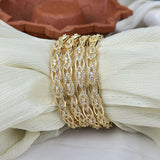 Gold bracelet with diamond accents on a white fabric background