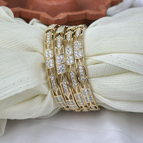 Gold bracelet with diamond accents on a white fabric background