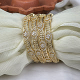 Gold bracelet with diamond accents on a white fabric background