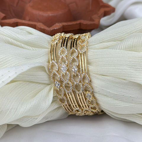 Gold bracelet with diamond accents on a white fabric background