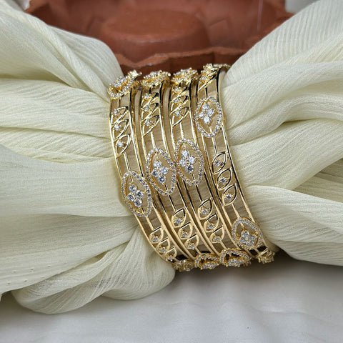Gold bracelet with diamond accents on a white fabric background