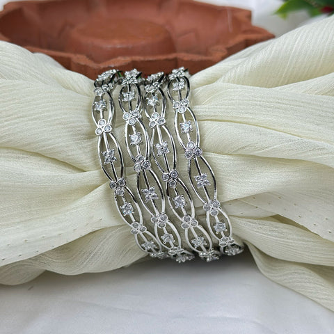 Silver bracelet with floral designs on a white fabric background