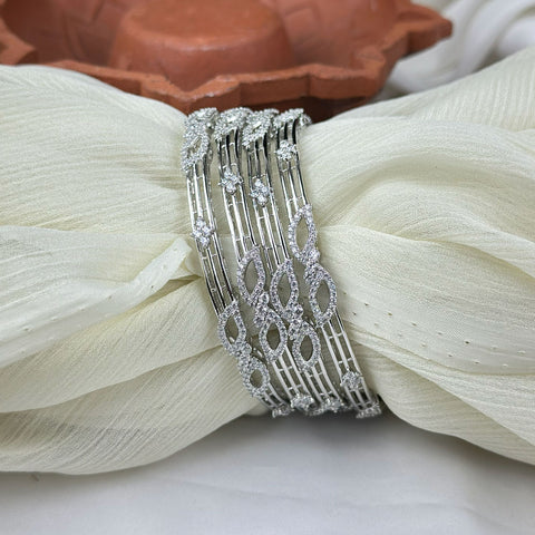 Silver bracelet with intricate design on a white fabric background