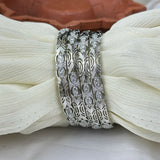 Silver bracelet with gemstones on a white fabric background