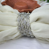 Silver bracelet with floral design on a white fabric background