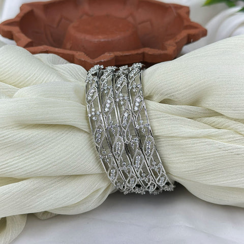 Silver bracelet with intricate design on a white fabric background