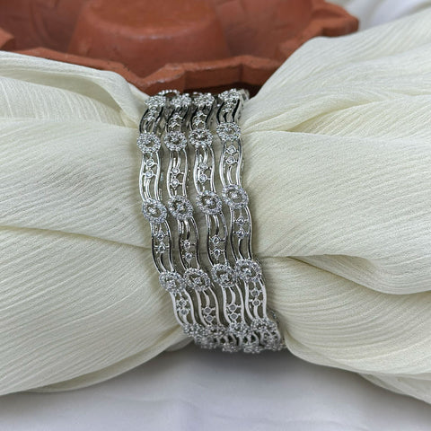 Silver bracelet with diamond accents on a white fabric background