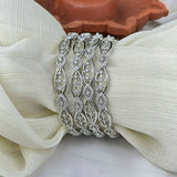 Silver bracelet with diamond accents on a white fabric background