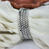 Set of silver rings with diamond accents on a white fabric background