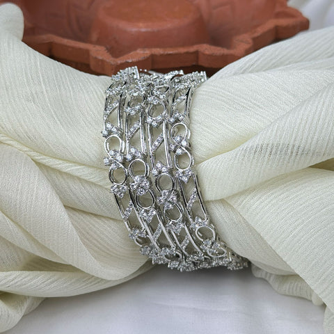 Silver bracelet with intricate design on a white fabric background