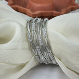Silver bracelet with gemstones on a textured white surface