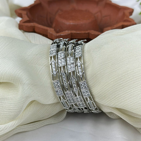 Silver bracelet with diamond accents on a white fabric background