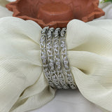 Silver bracelet with clear stones on a white fabric background