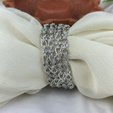 Silver bracelet with clear stones on a white fabric background