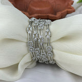 Silver bracelet with floral design on a white fabric background