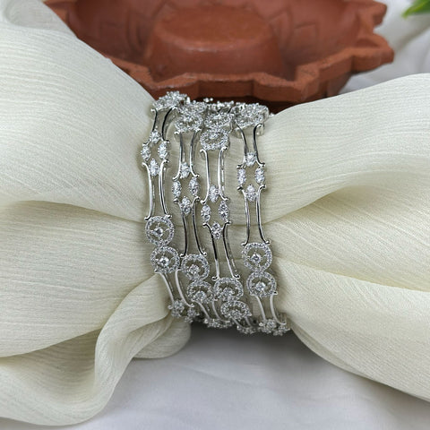 Silver bracelet with floral design on a white fabric background