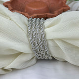 Silver decorative brooch on a white fabric background