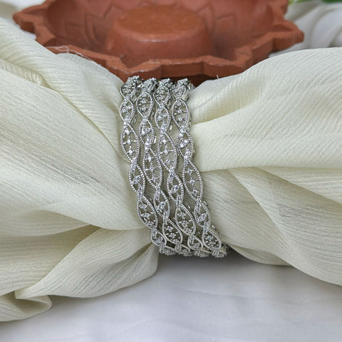 Silver decorative brooch on a white fabric background