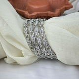 Silver bracelet with clear stones on a white fabric background