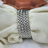 Silver bracelet with diamond accents on a white fabric background