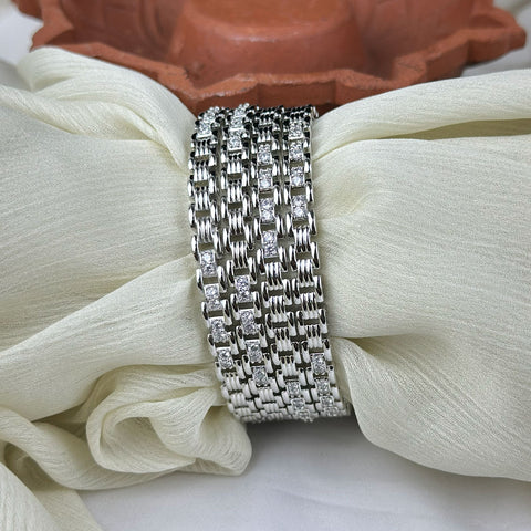 Silver bracelet with diamond accents on a white fabric background
