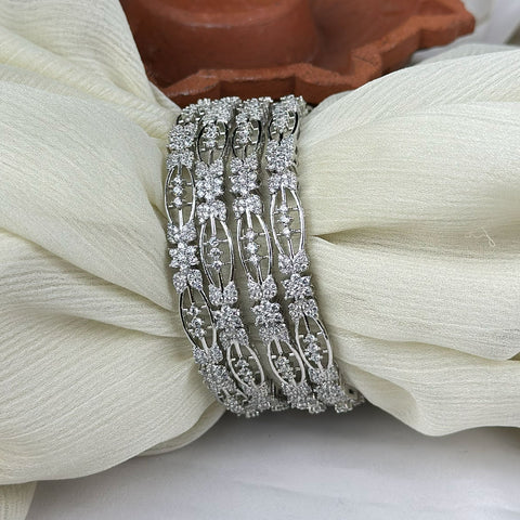Silver bracelet with floral design on a white fabric background
