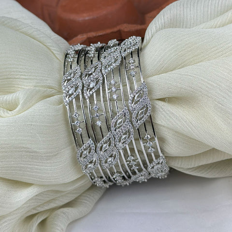 Silver bracelet with leaf designs on a white fabric background