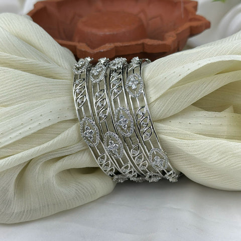 Set of silver bangles on a white fabric background