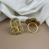 Gold earrings with intricate designs on a beige surface with white fabric in the background