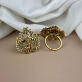 Gold earrings with intricate designs on a beige surface with white fabric in the background