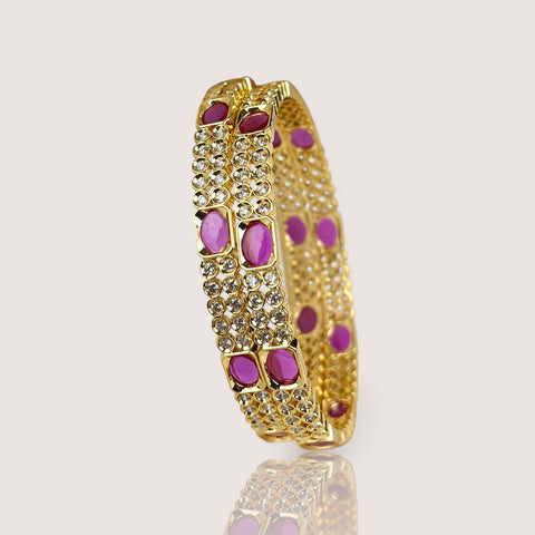 Gold bracelet with purple stones on a light beige background
