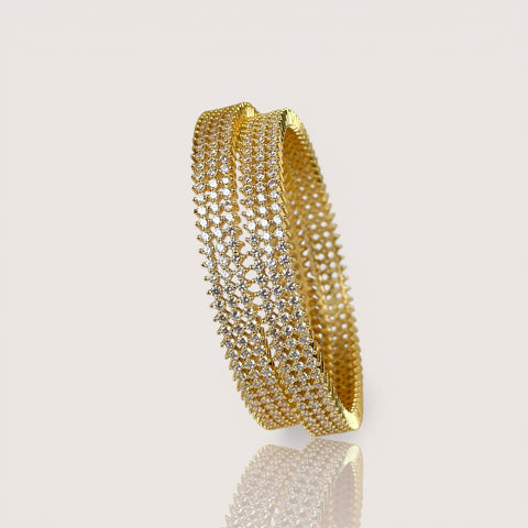 Gold bracelet with clear stones on a beige background