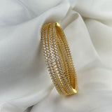 Gold bracelet with clear stones on a white fabric background
