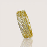 Gold bracelet with clear stones on a light beige background
