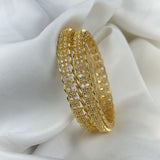 Gold bracelet with clear stones on a white fabric background