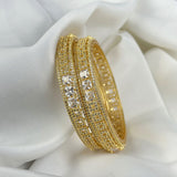 Gold bracelet with embedded crystals on a white fabric background