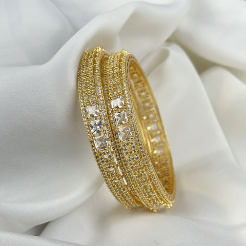Gold bracelet with embedded crystals on a white fabric background