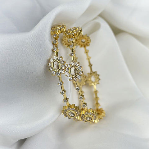 Gold earrings with gemstones on a white fabric background