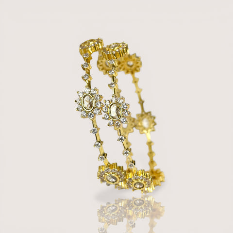 Gold earrings with gemstones on a light beige background