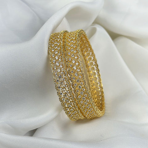 Gold bracelet with clear stones on a white fabric background