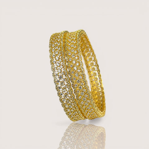 Gold bracelet with embedded diamonds on a light beige background