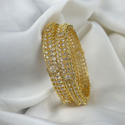 Gold bracelet with clear stones on a white fabric background