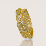 Gold bracelet with clear stones on a light gray background