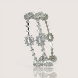 Silver bracelet with star-shaped charms on a light gray background
