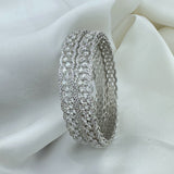 Silver ring with multiple rows of diamonds on a white fabric background